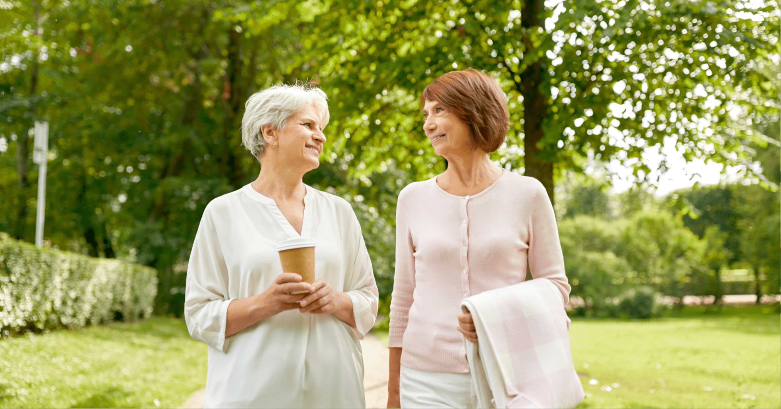 two senior women taking a walk outdoors around a senior living community