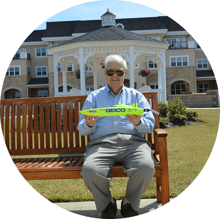 Senior man smiling on a bench outside of Searstone