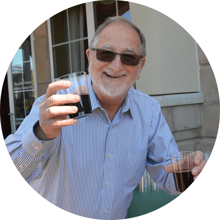 Senior man smiling with a glass of wine in his hand