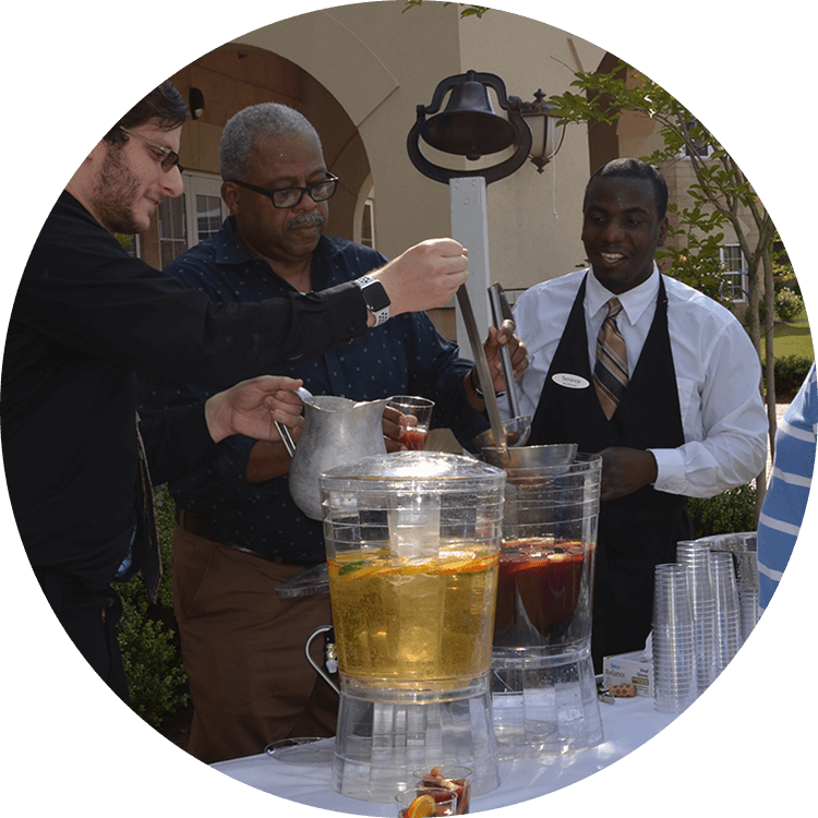Senior living staff pouring drinks at a community event