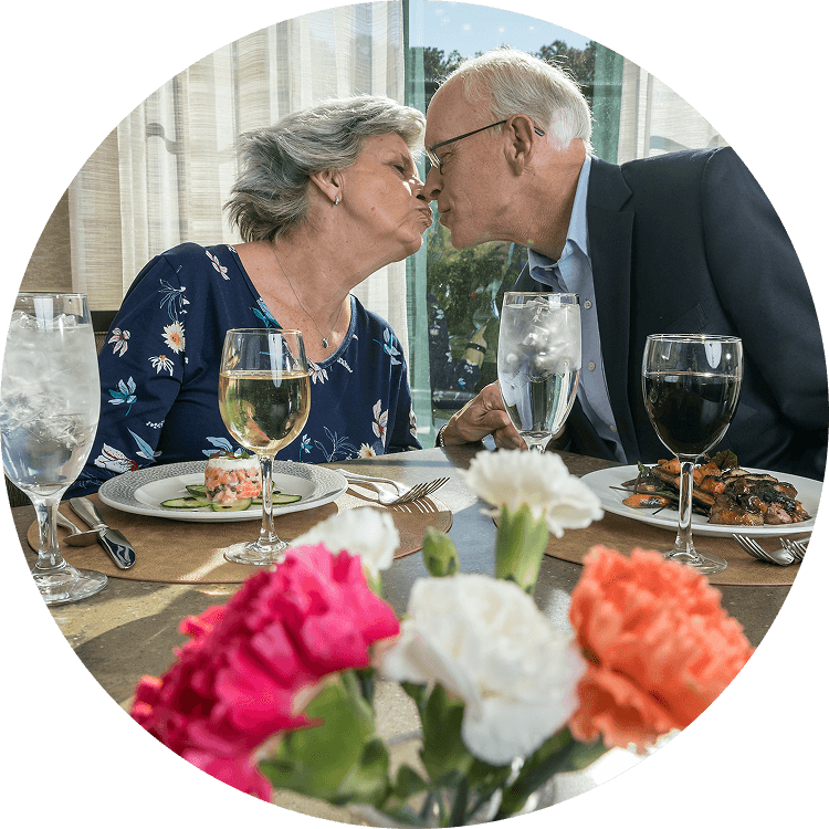 Elderly couple kissing while enjoying dinner at Searstone