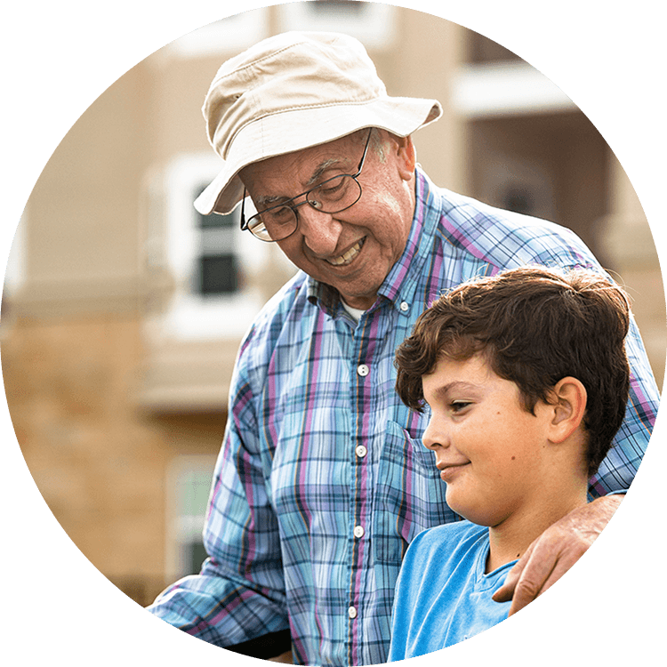 Elderly man smiling while fishing with his grandson