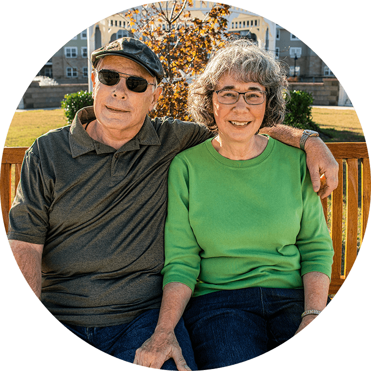 A senior couple smiling on a bench