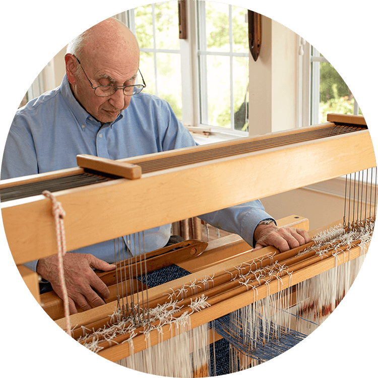Senior man using a floor loom
