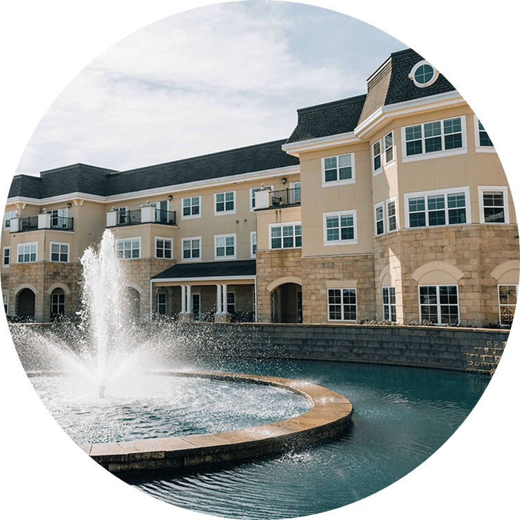 Exterior view of Searstone Retirement Community featuring a water fountain