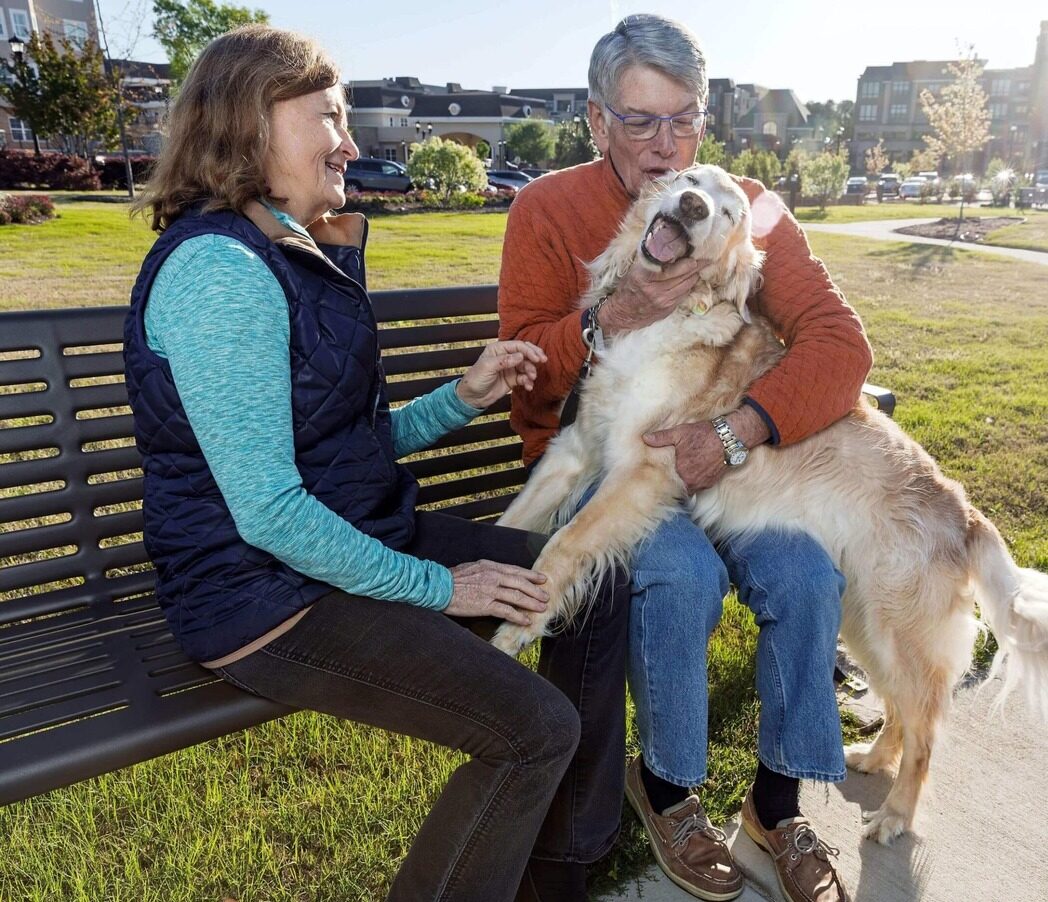 Healthy seniors with their dog enjoying the outdoors in a retirement community